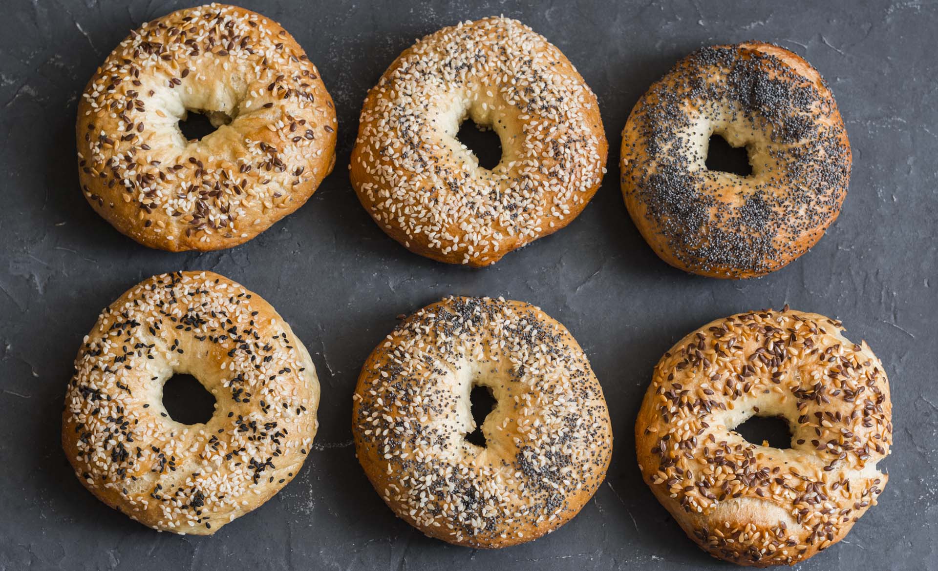 Six bagels with toppings.