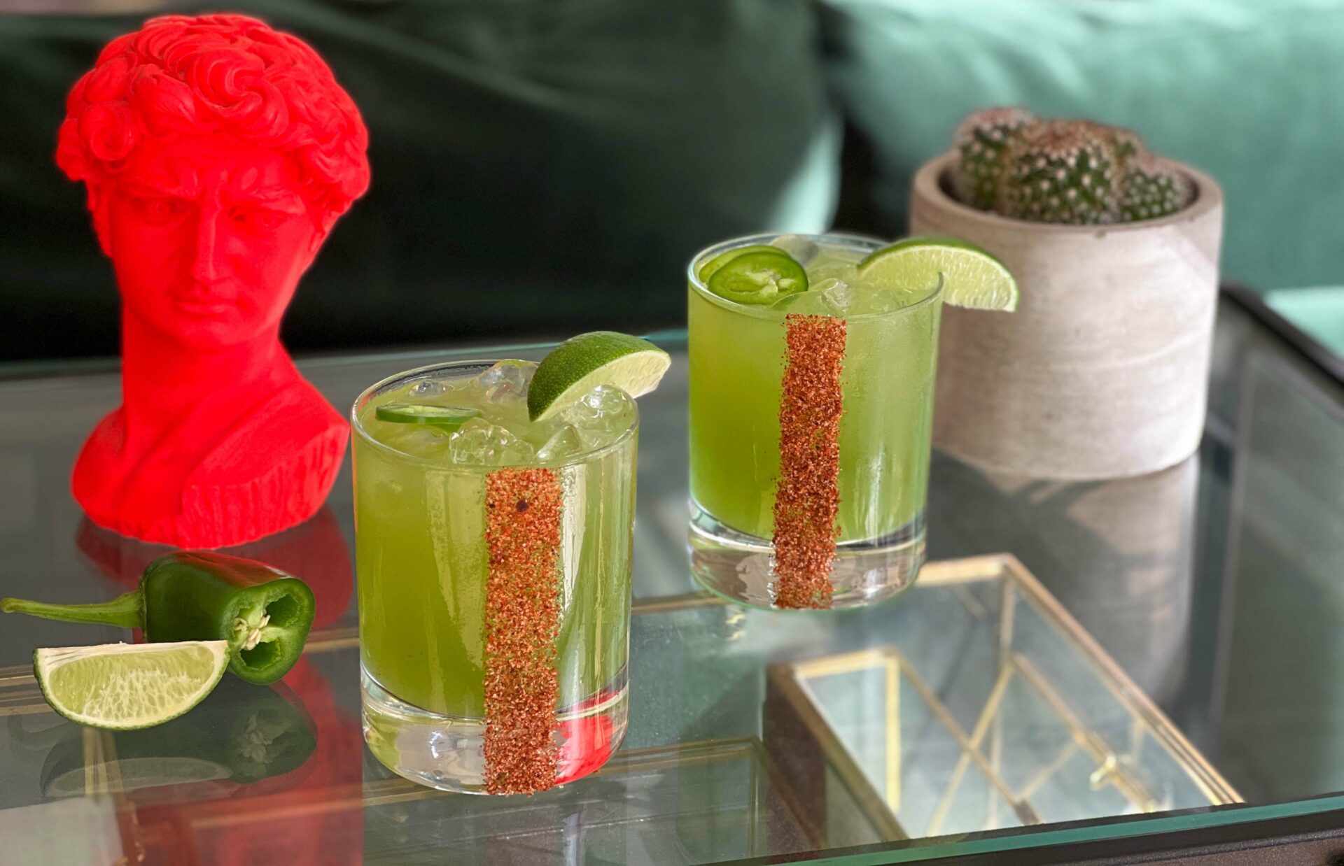 Two Green Sapphire Margaritas garnished with jalapeno and a lime wedge.