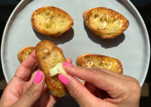 Rubbing a garlic clove to pieces of bread.