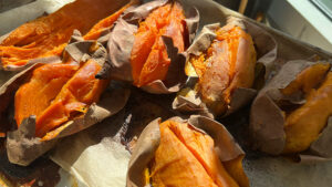 Baked sweet potatoes on a lined baking sheet.