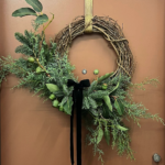 A Whimsical Christmas wreath hanging on a door.